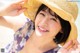 A woman wearing a straw hat on the beach.