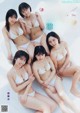 A group of women in white bikinis posing for a magazine cover.