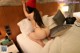 A woman in a red hat is sitting on a bed.