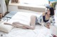 A woman laying on a bed in a blue and white lingerie.