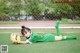 A young girl laying on the ground with a soccer ball.