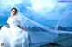 A woman in a wedding dress standing on a dock.